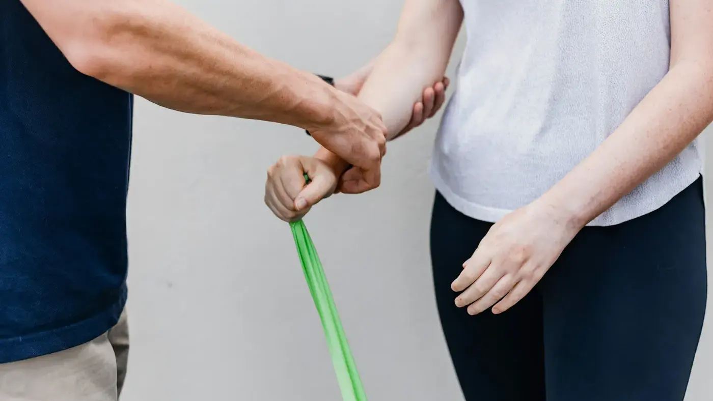 Physiotherapist coaching a resistance band exercise
