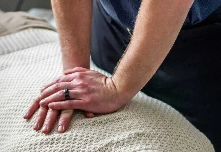 Chiropractor's hands positioned on a patient's upper back during an adjustment