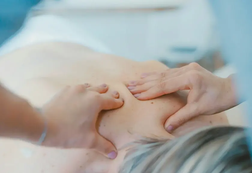 Massage therapist working on a patient's upper back and shoulders